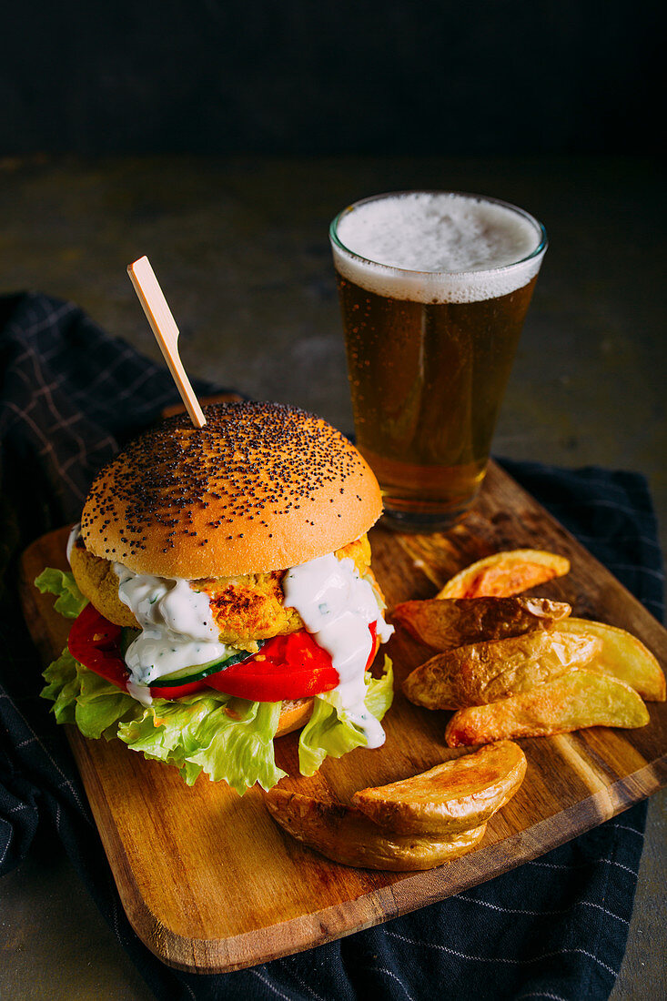 Vegetarischer Kichererbsenburger mit Pommes und einem Glas Bier