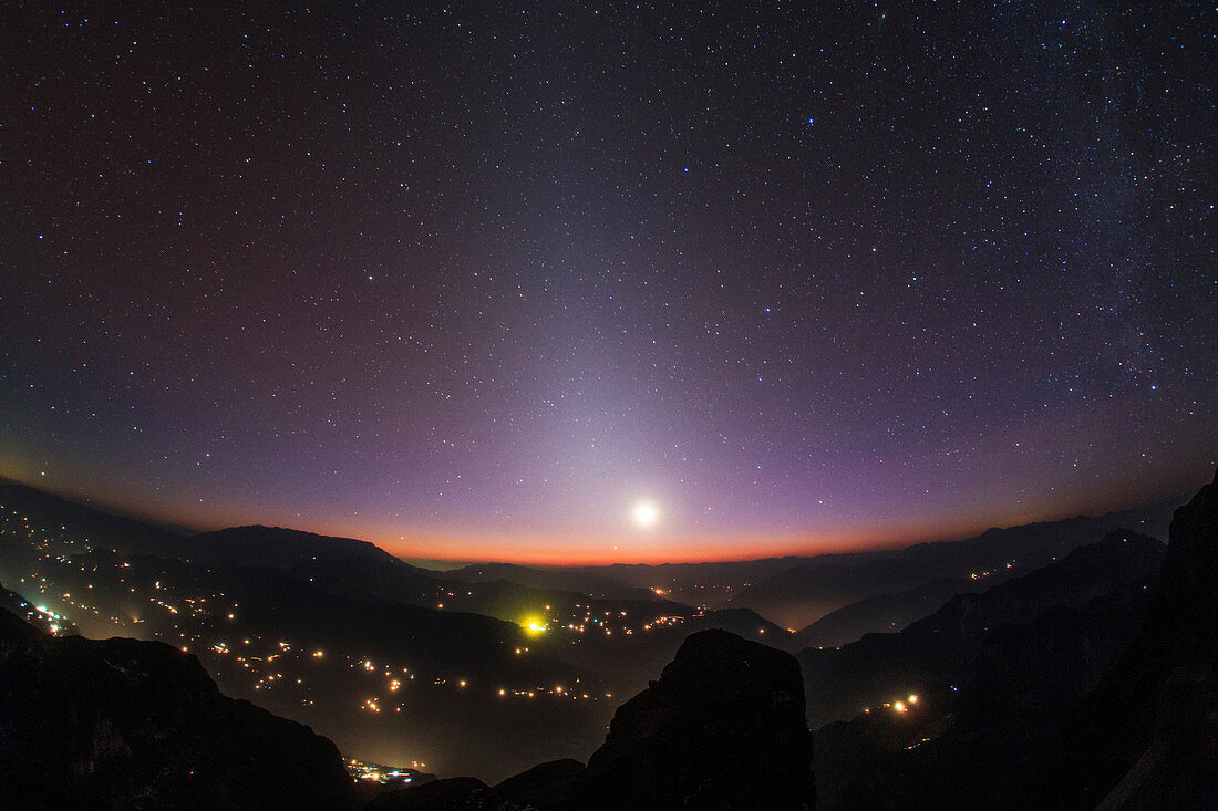 Moon on horizon at night with zodiacal light