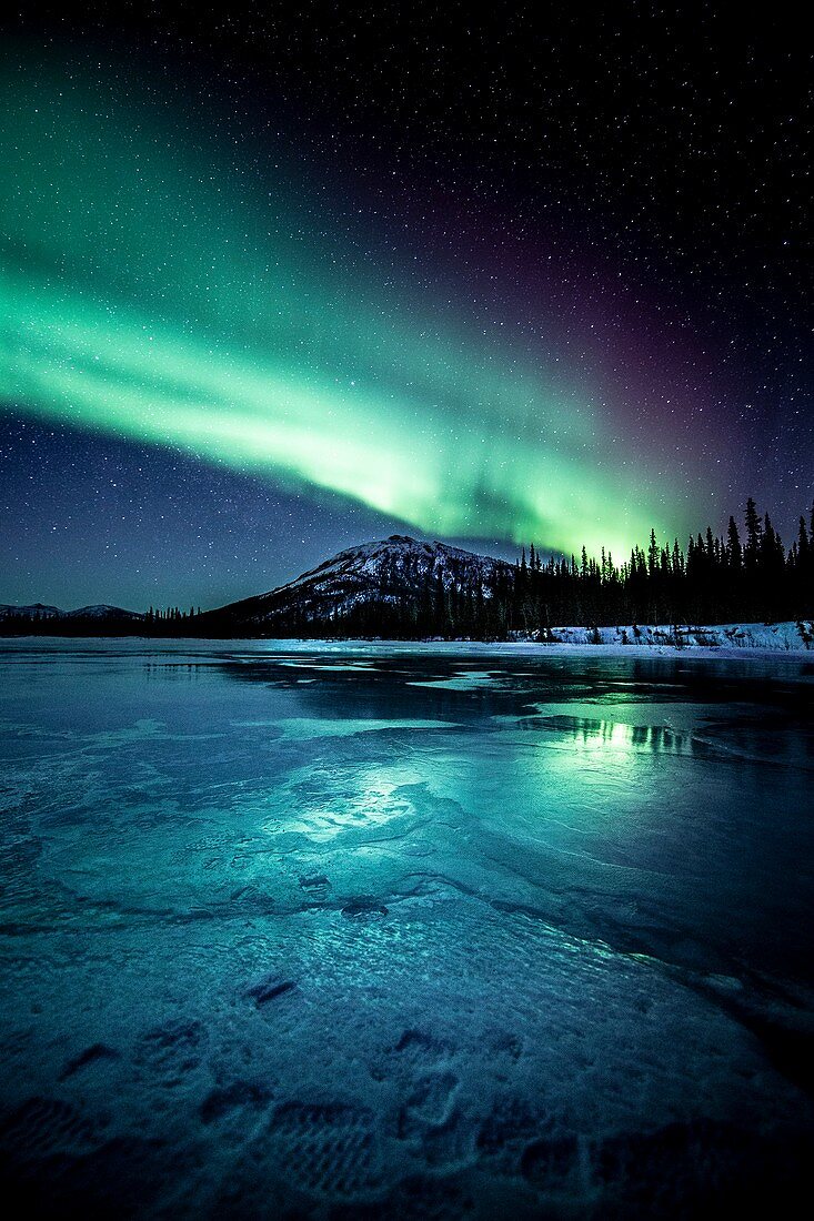 Aurora over a frozen river in Alaska, USA