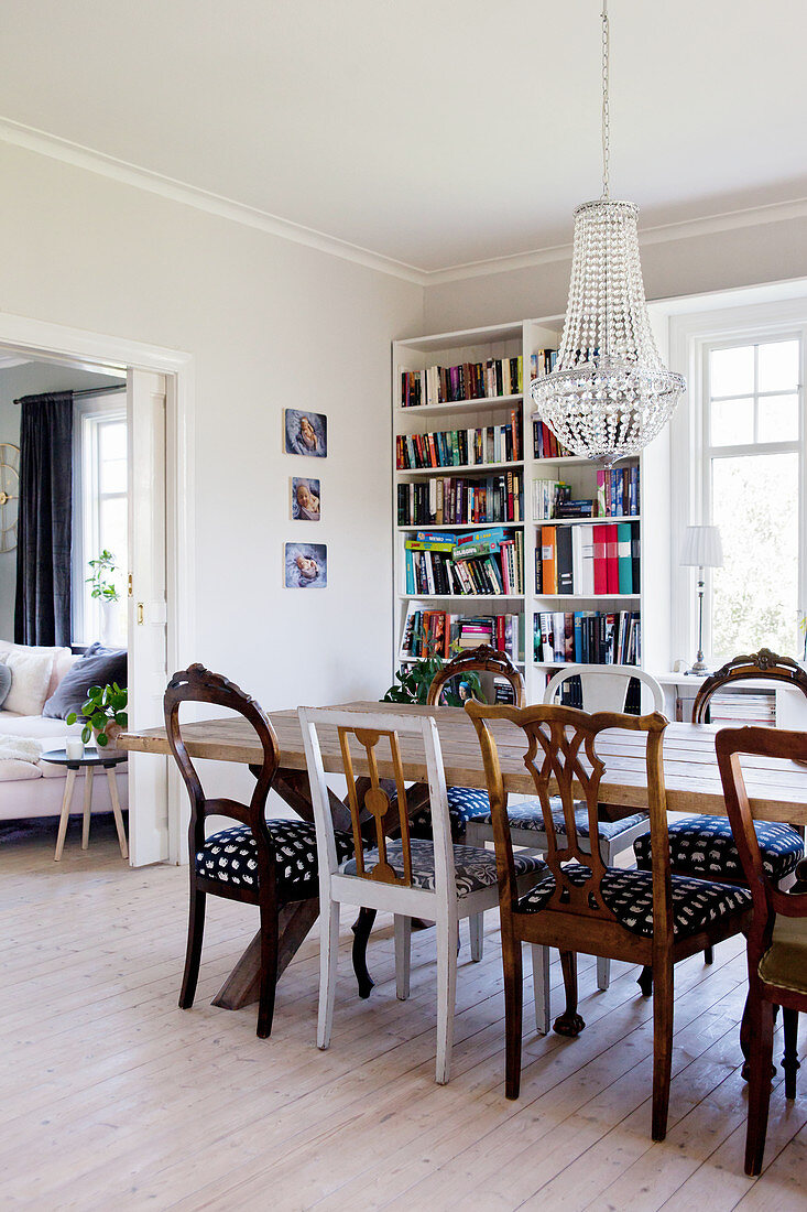 Long wooden table and various chairs in dining room