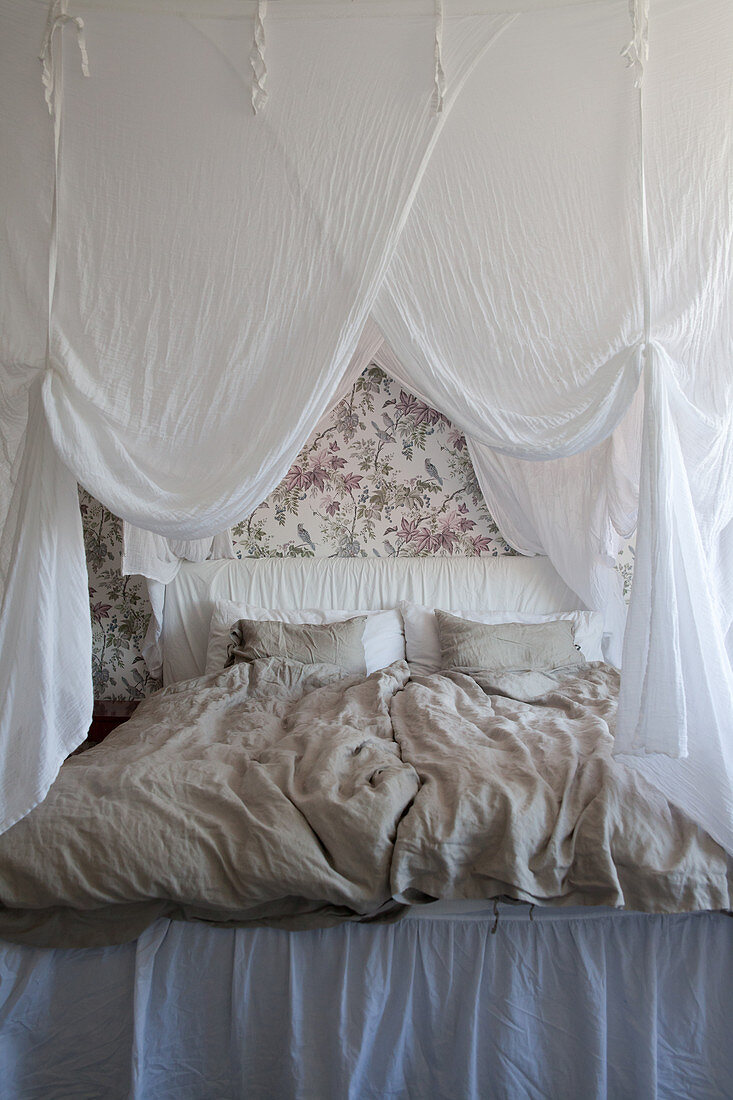 Double bed with white canopy in bedroom