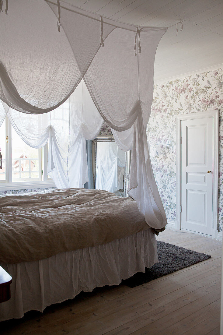 Doppelbett mit weißem Betthimmel im Schlafzimmer mit nostalgischer Tapete