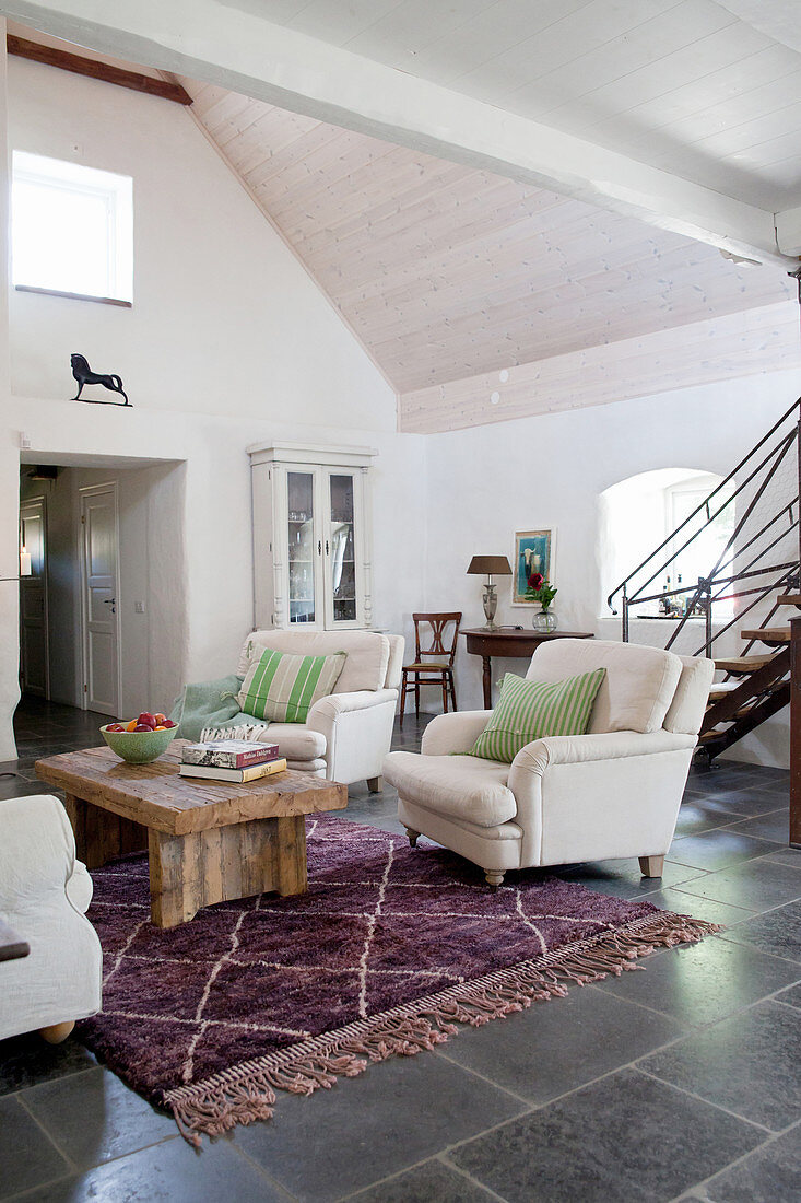 Exposed roof structure and black floor tiles in living room