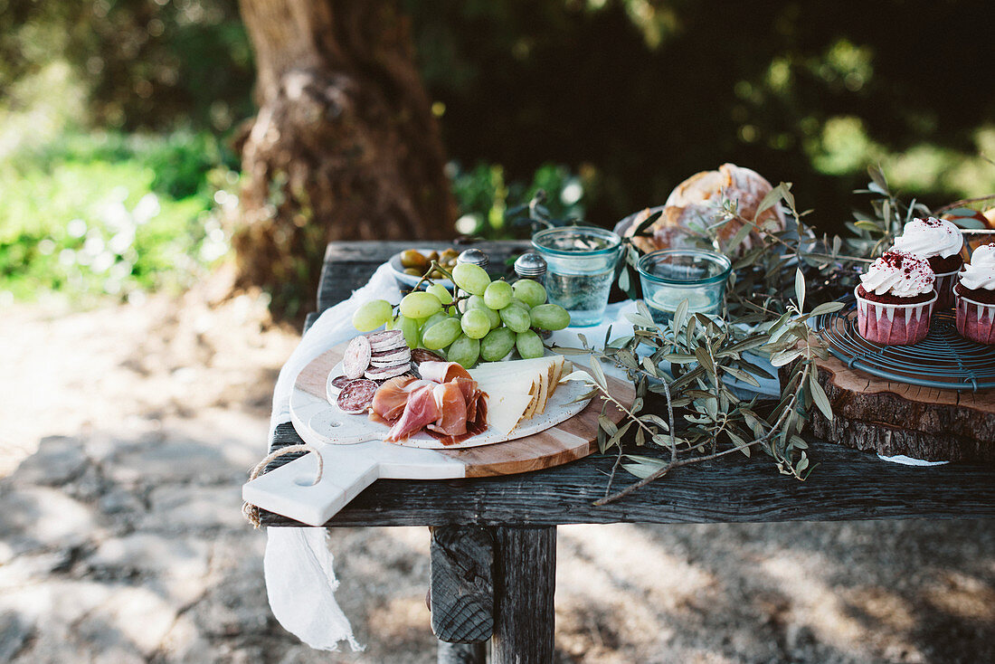 Various delectable food standing on lumber table in garden on sunny day