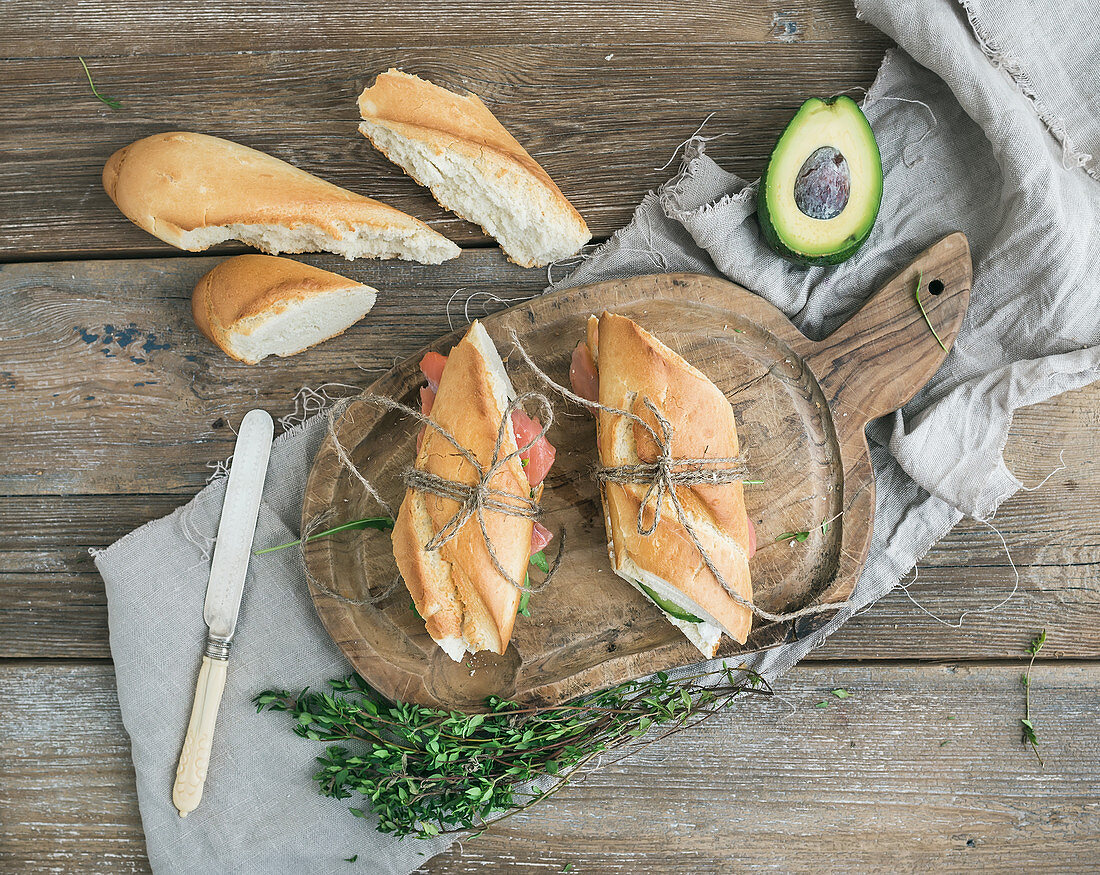 Salmon and avocado sandwiches with fresh thyme in baguette