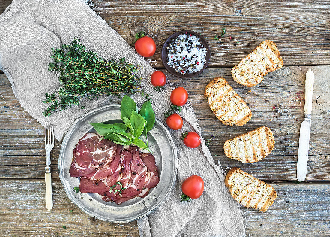 Smoked meat with fresh basil, cherry-tomatoes and bread