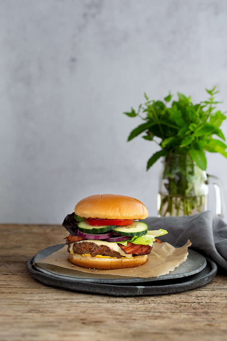 Cheeseburger mit Speck, Zwiebeln, Gurken und Tomaten