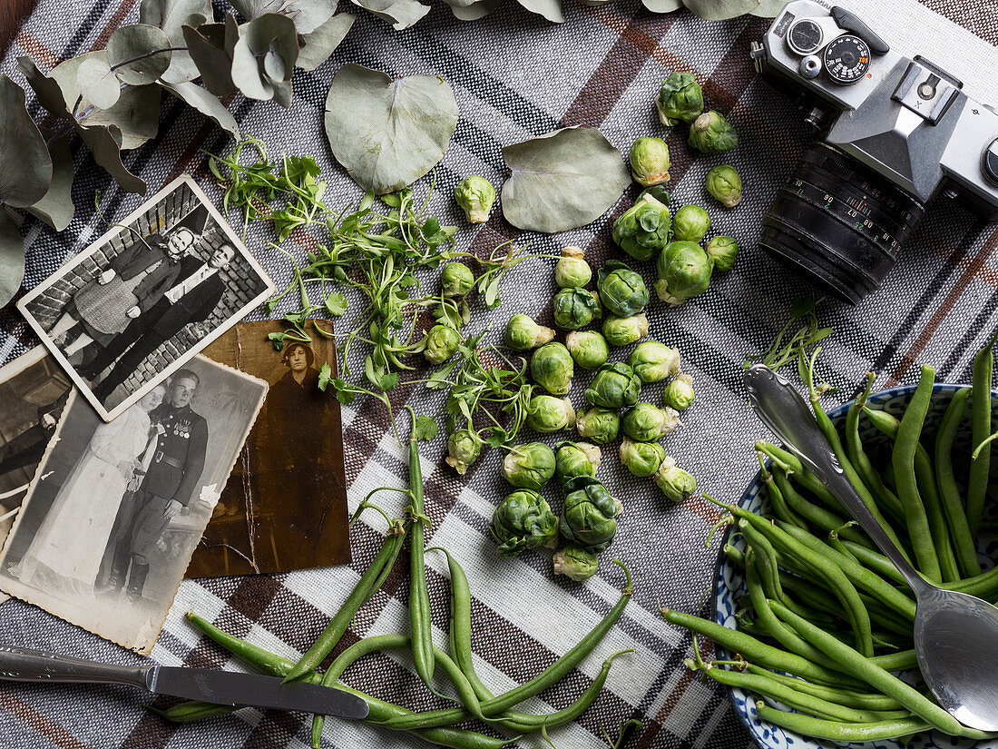 Green beans and Brussels sprouts surrounded by old black-and-white photos