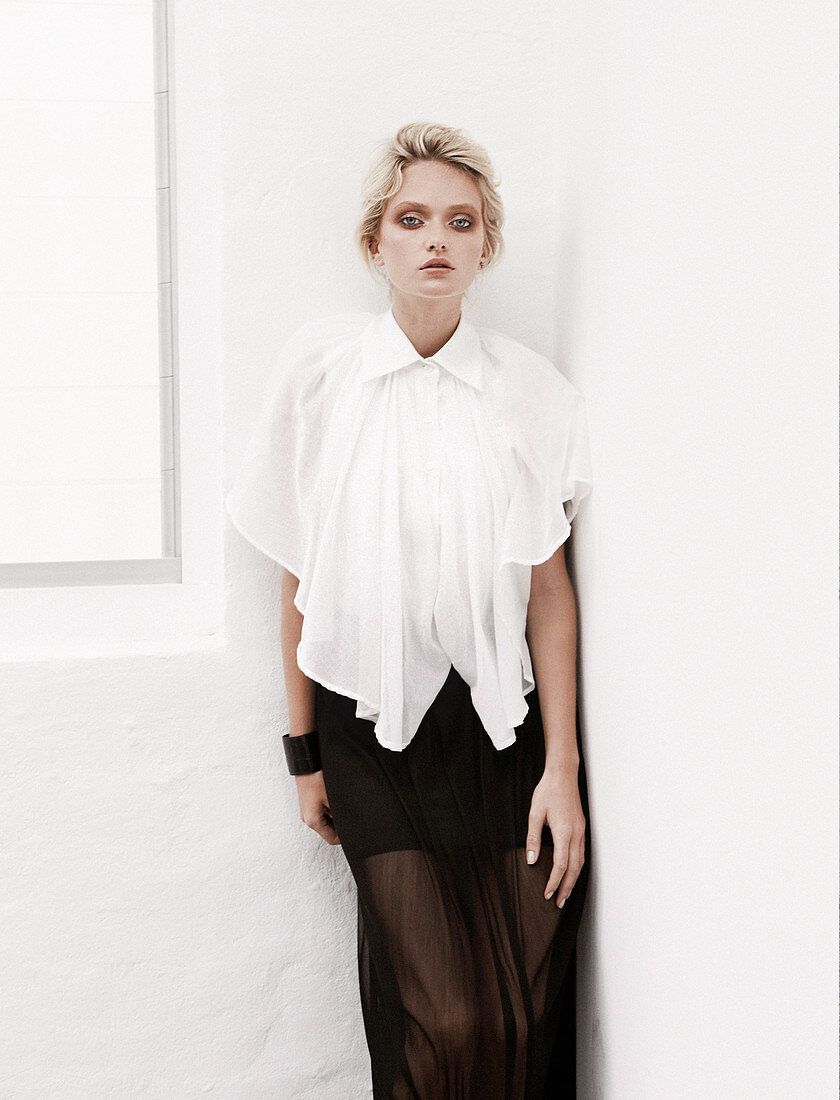 A blonde woman wearing a white blouse and a black skirt