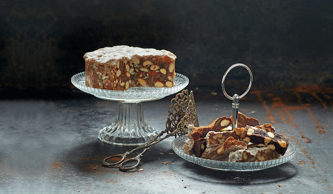 Panforte on a cake stand with cake tongs