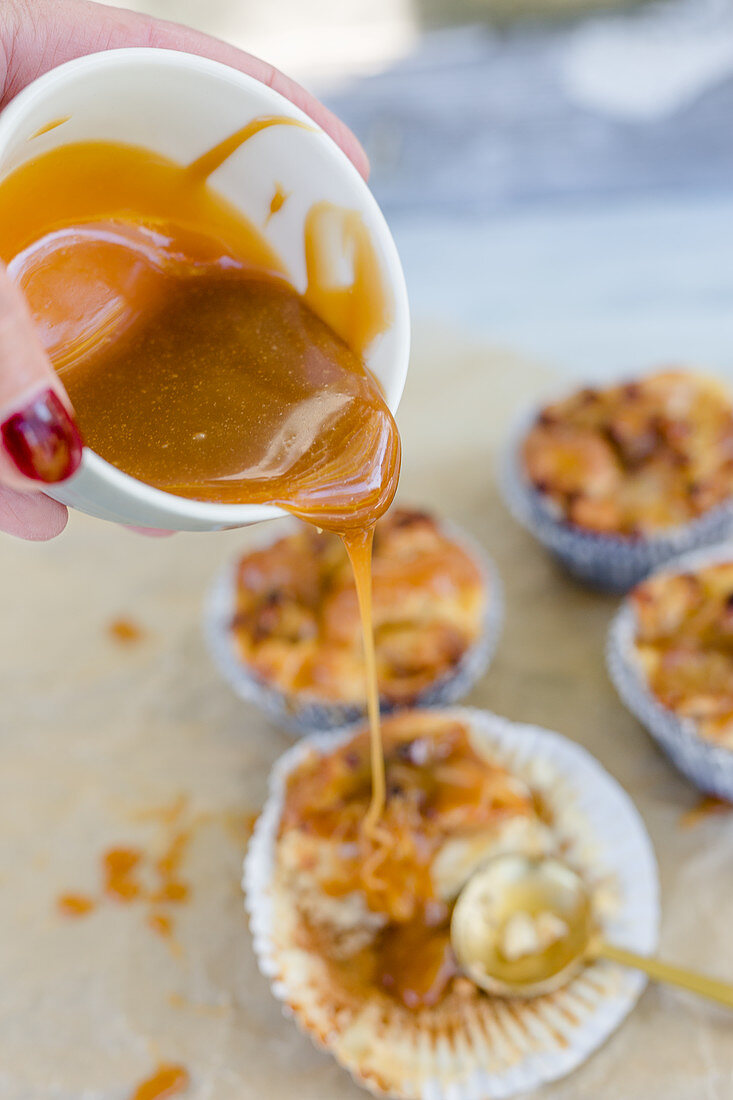 Caramel sauce being poured over apple muffins