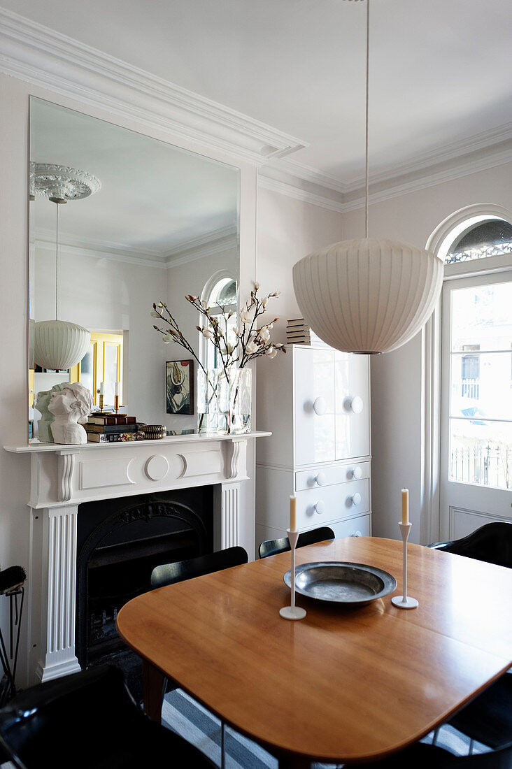 Dining table next to open fireplace in classic period building with stucco ceiling