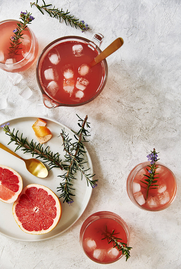 Pink Grapefruit Mocktail mit Rosmarin in Karaffe und Gläsern (Aufsicht)