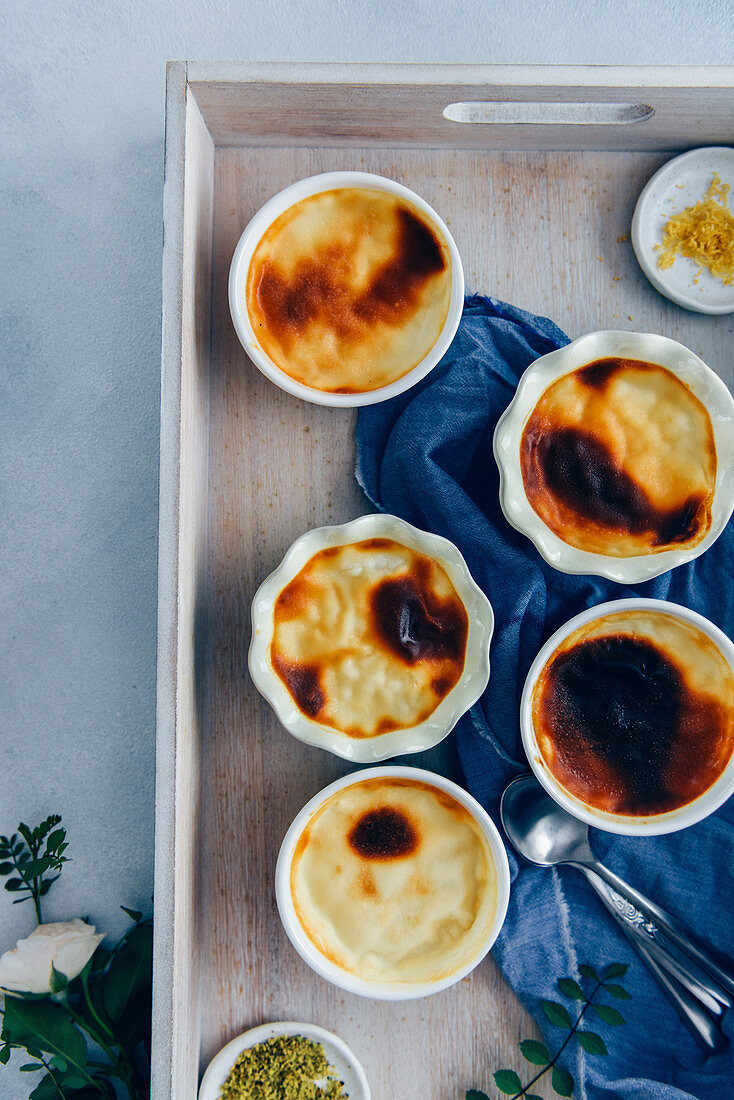 Creamy baked rice pudding in ramekins served in a wooden tray