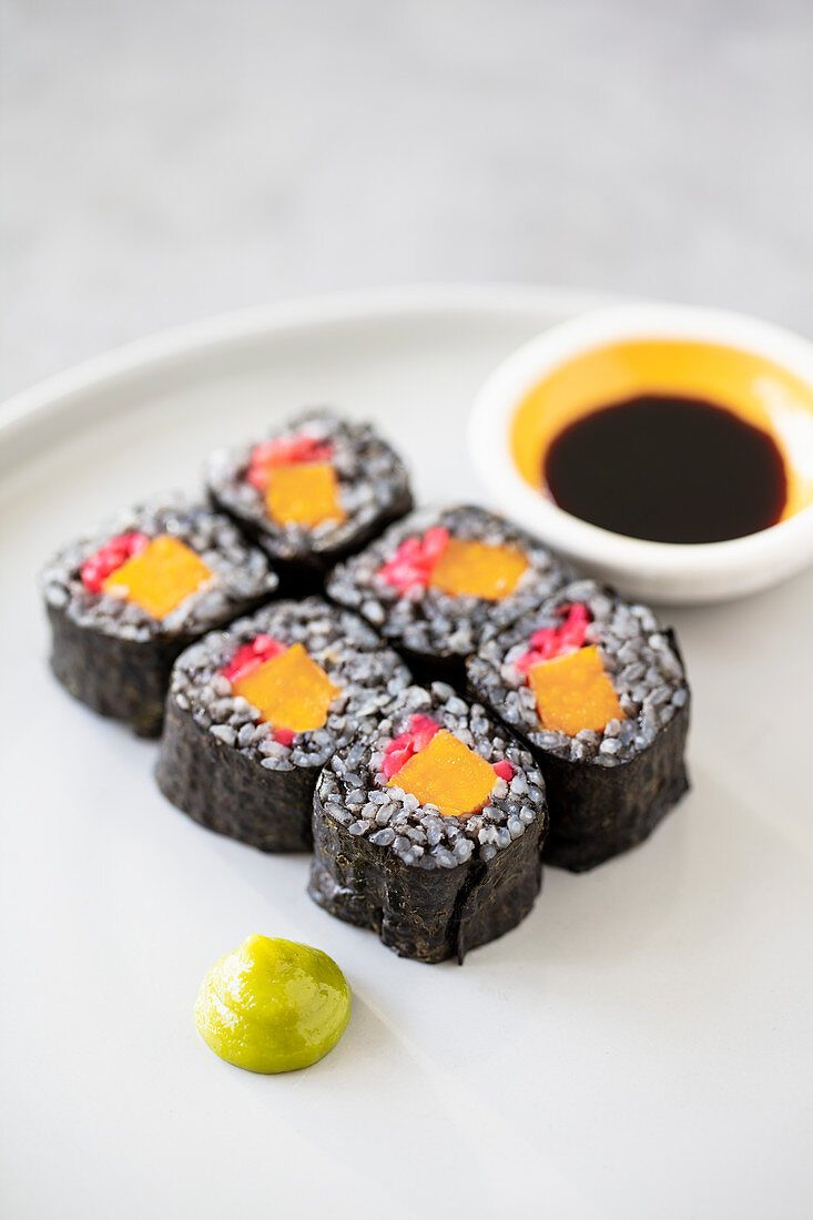 Vegane Maki-Sushi mit schwarzem Reis, Süßkartoffel und rosa Ingwer