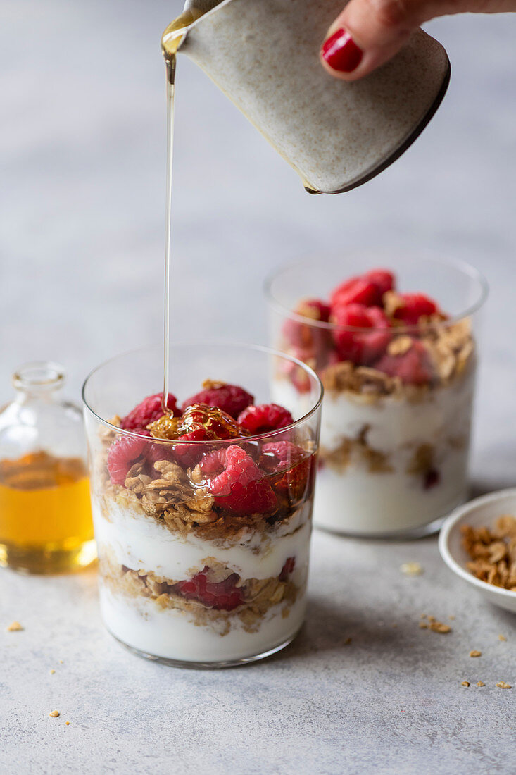 Yogurt and granola parfait with raspberries and honey