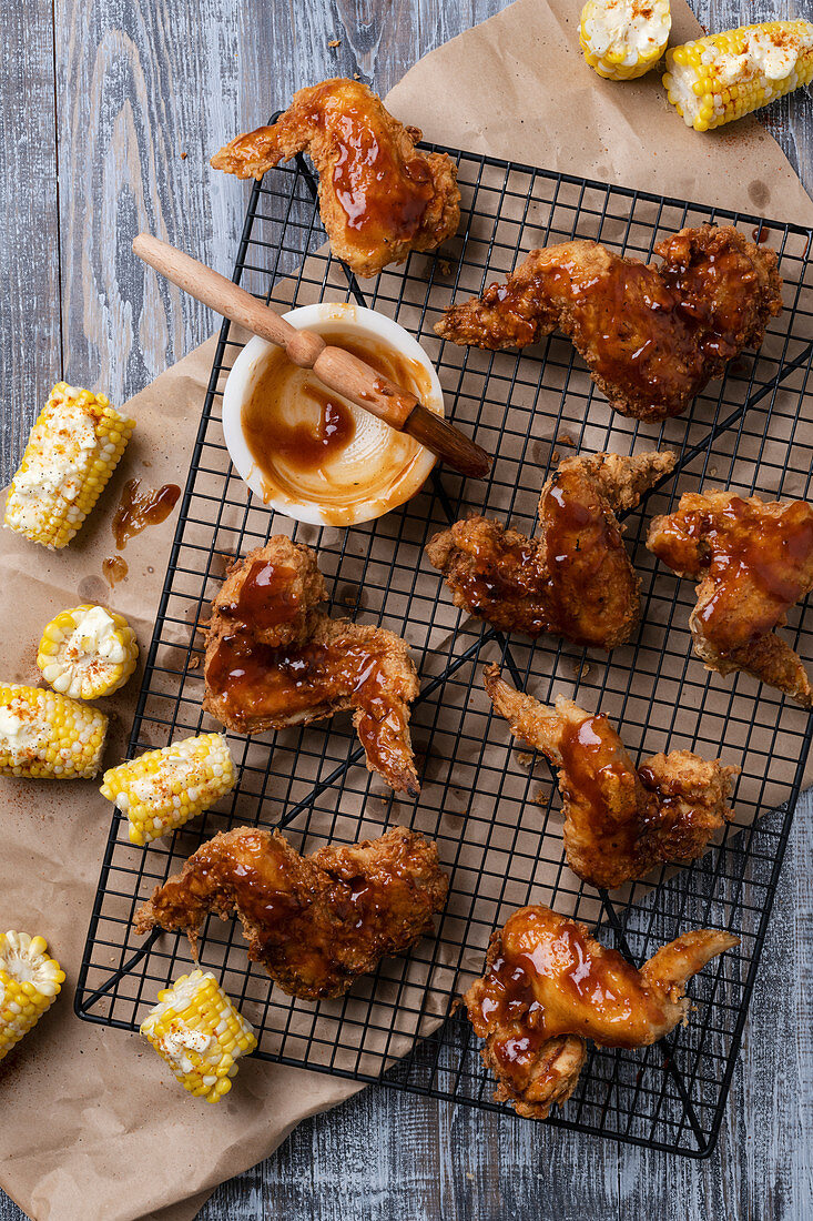 Frittierte Chicken Wings mit BBQ-Sauce und Maiskolben (Aufsicht)
