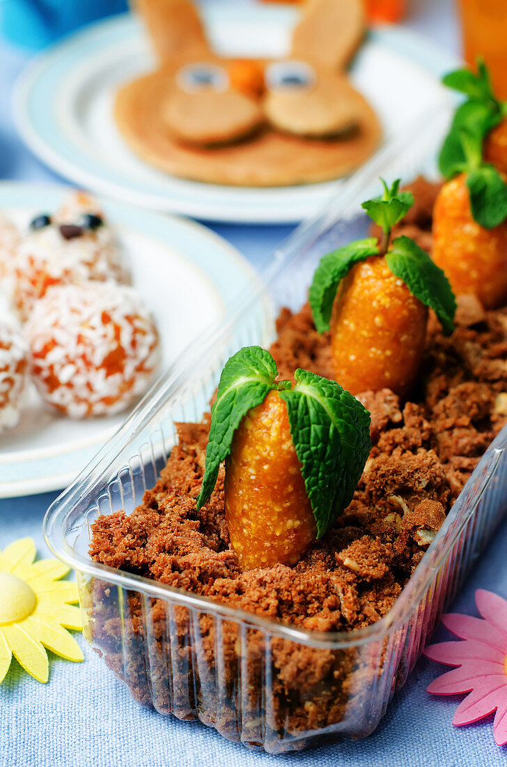 Chocolate biscuit and dried apricots cashew candies in the form of carrots for children