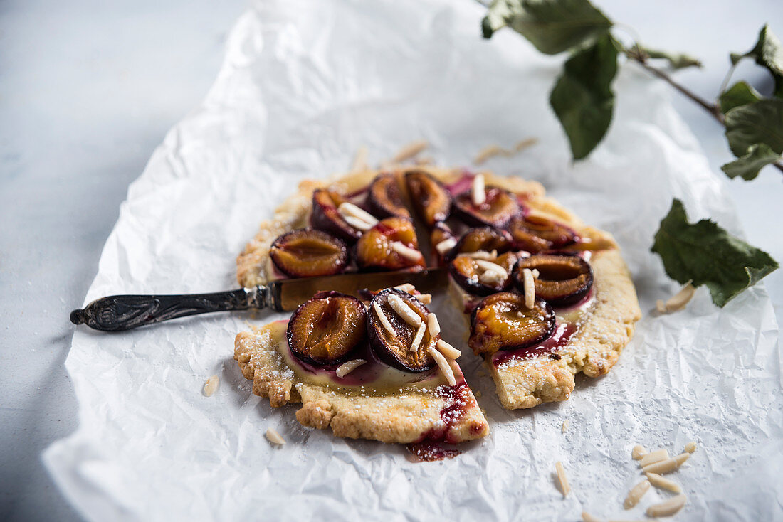 Vegan shortcrust pastry topped with damsons and almonds