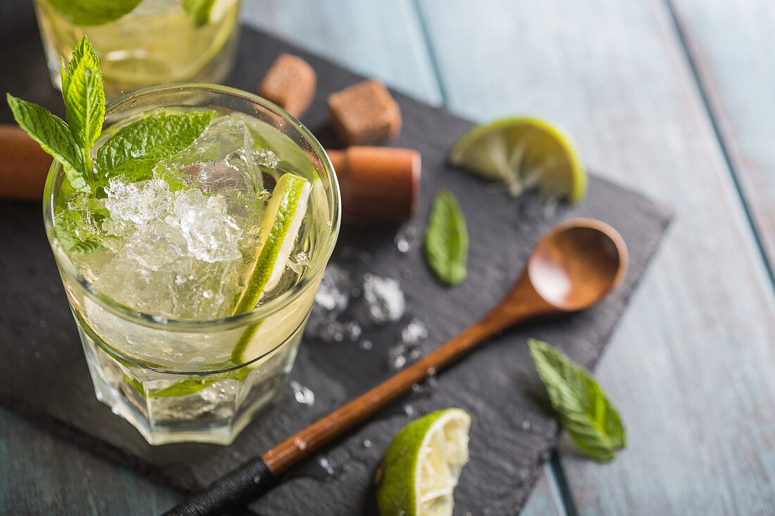 Mojito im Glas mit Limetten, Eiswürfeln und Minze