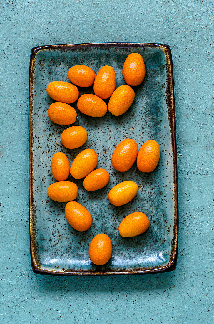 Kumquats on a blue craft plate