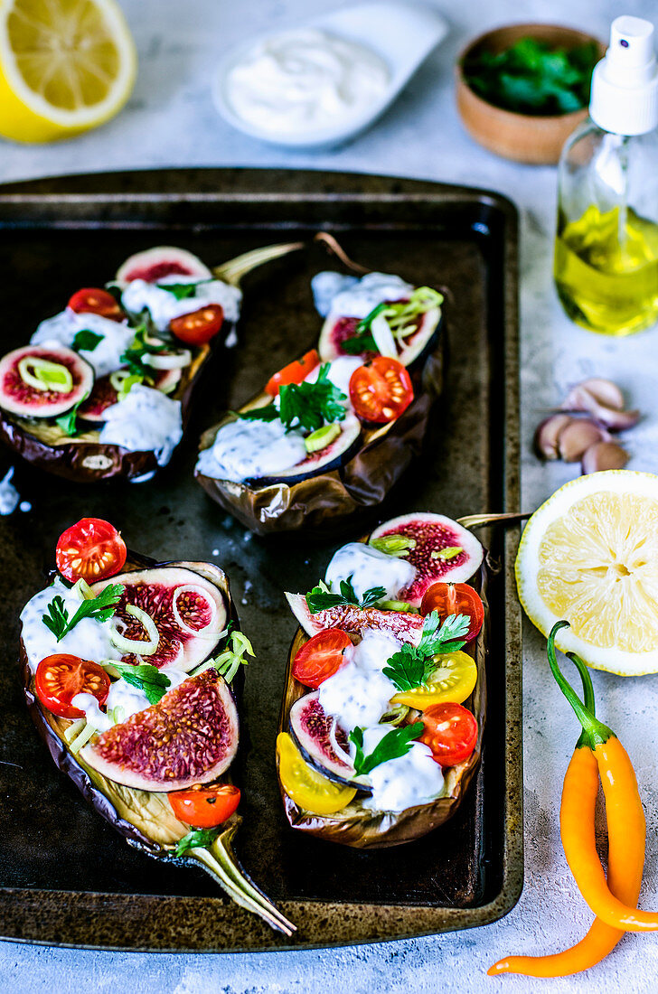 Baked eggplants with cherry tomatoes, figs, parsley and yogurt with chia seeds