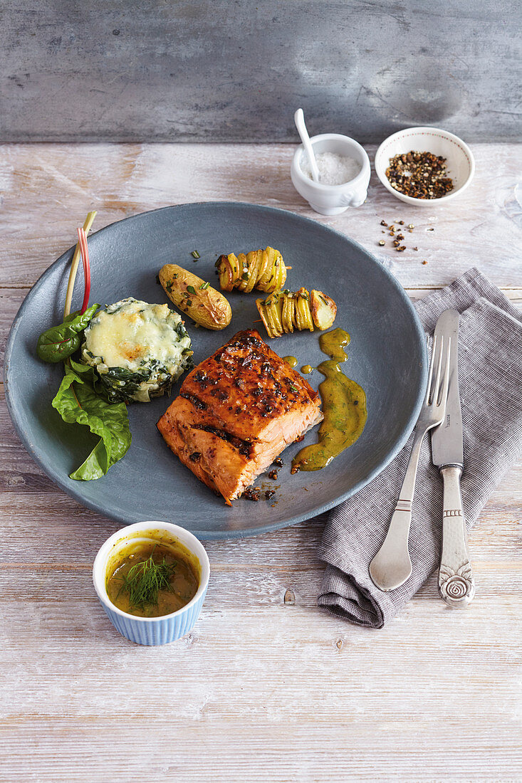 Gegrilltes Lachsfilet vom Holzbrett mit Mangoldtürmchen