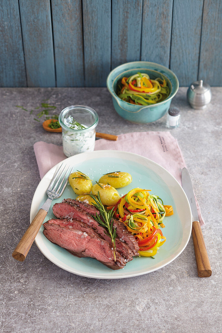 Flank steak on a bed of vegetable spirals with rosemary potatoes