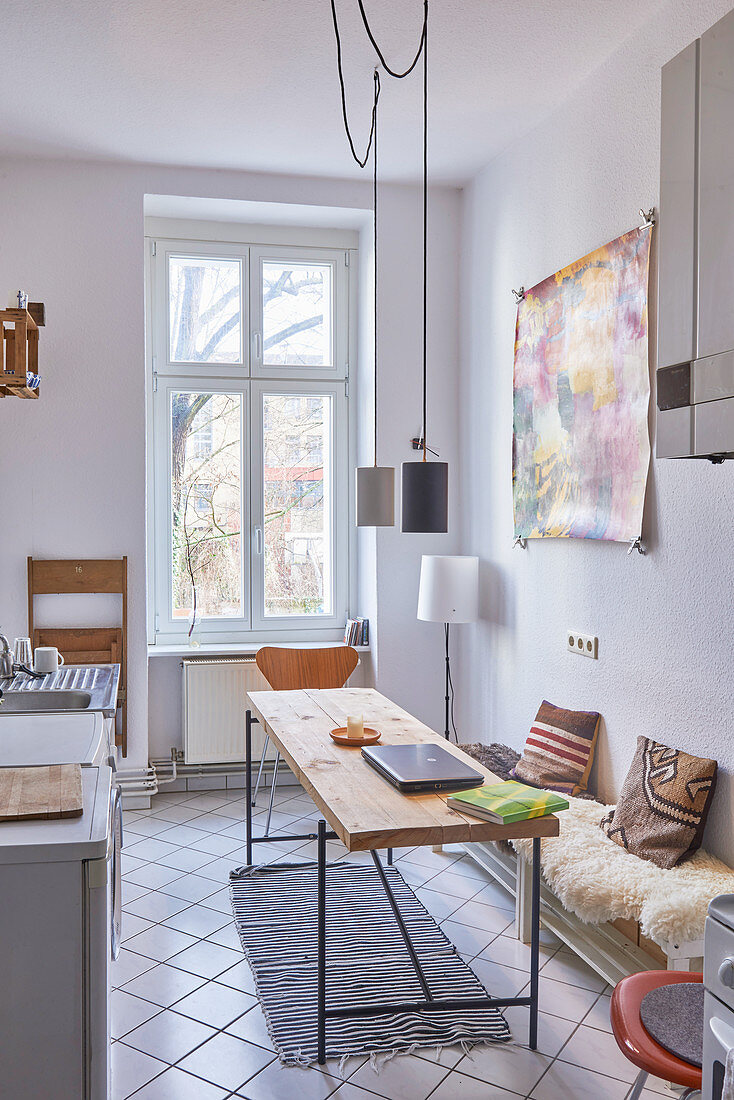 Tisch und Bank in einer schmalen Küche im Berliner Altbau
