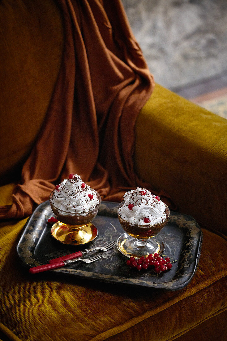 Schokoladenpudding mit Sahne und roten Johannisbeeren