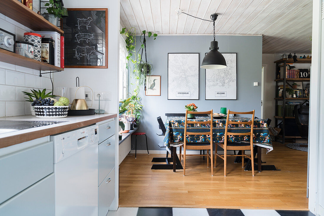 Open-plan kitchen with dining area on parquet floor and grey wall in background
