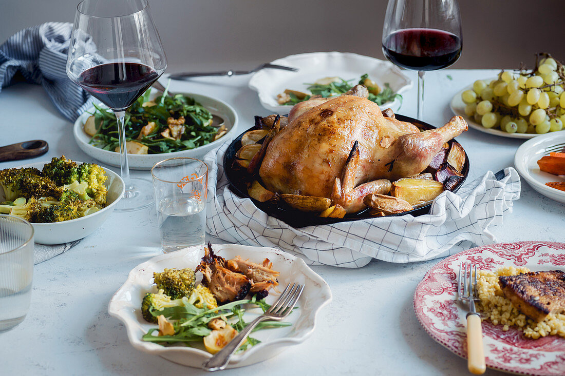 Big festive dinner with roasted chicken, wine and various garnishing