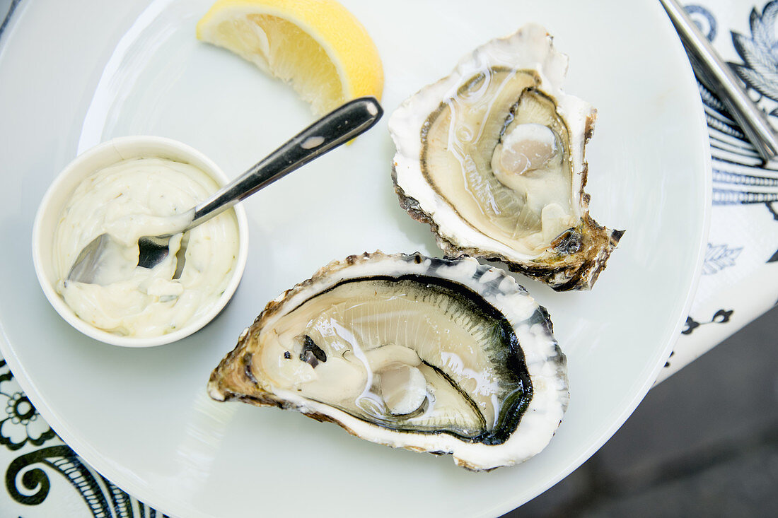 Oysters with mayonnaise sauce and lemon slices in french seafood restaurant