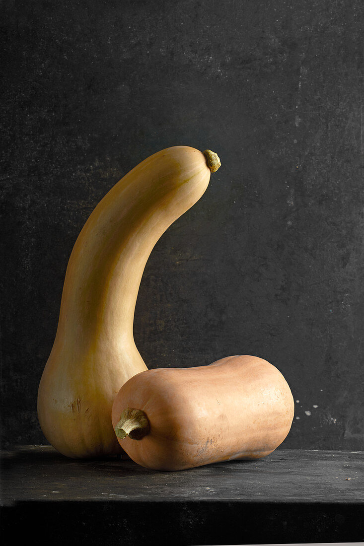 Two squash on a black surface