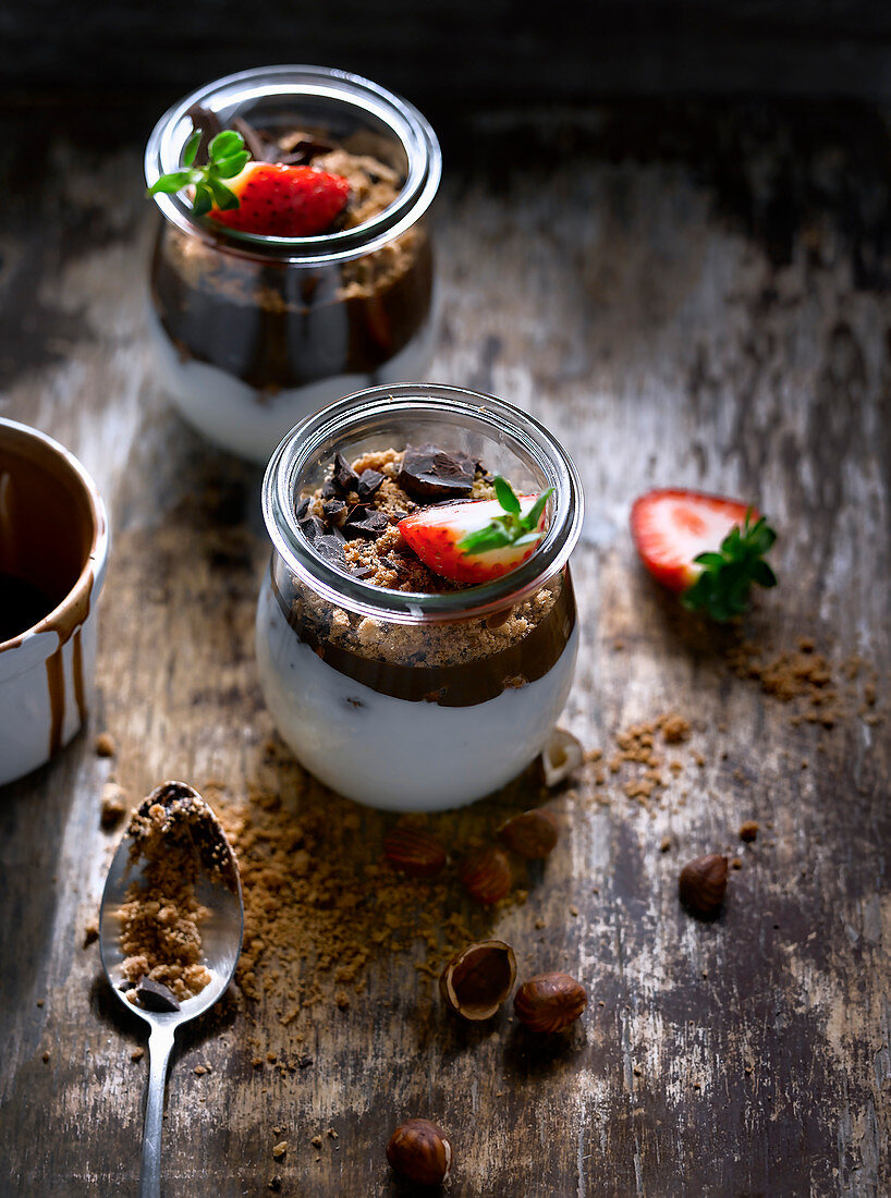 Dessert im Glas mit Joghurt, Schokolade, Haselnüssen und Erdbeeren