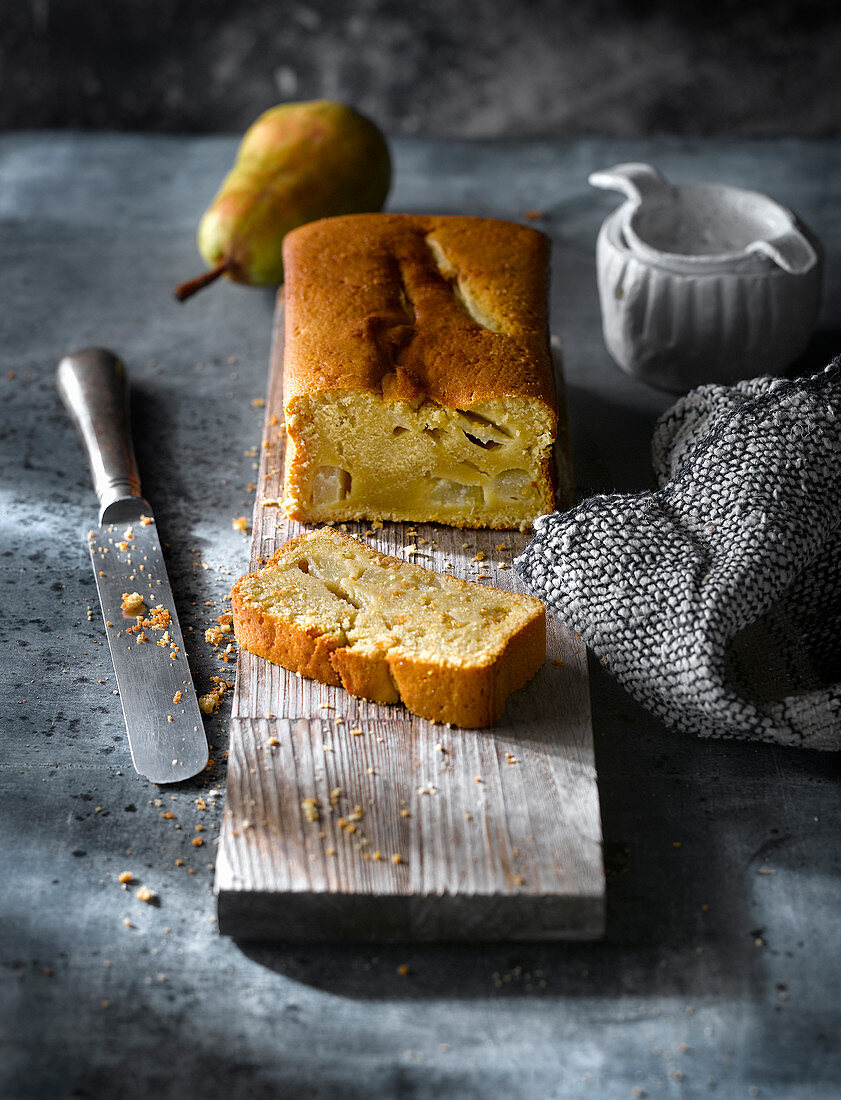 Freshly baked pear cake with tea on rustic table