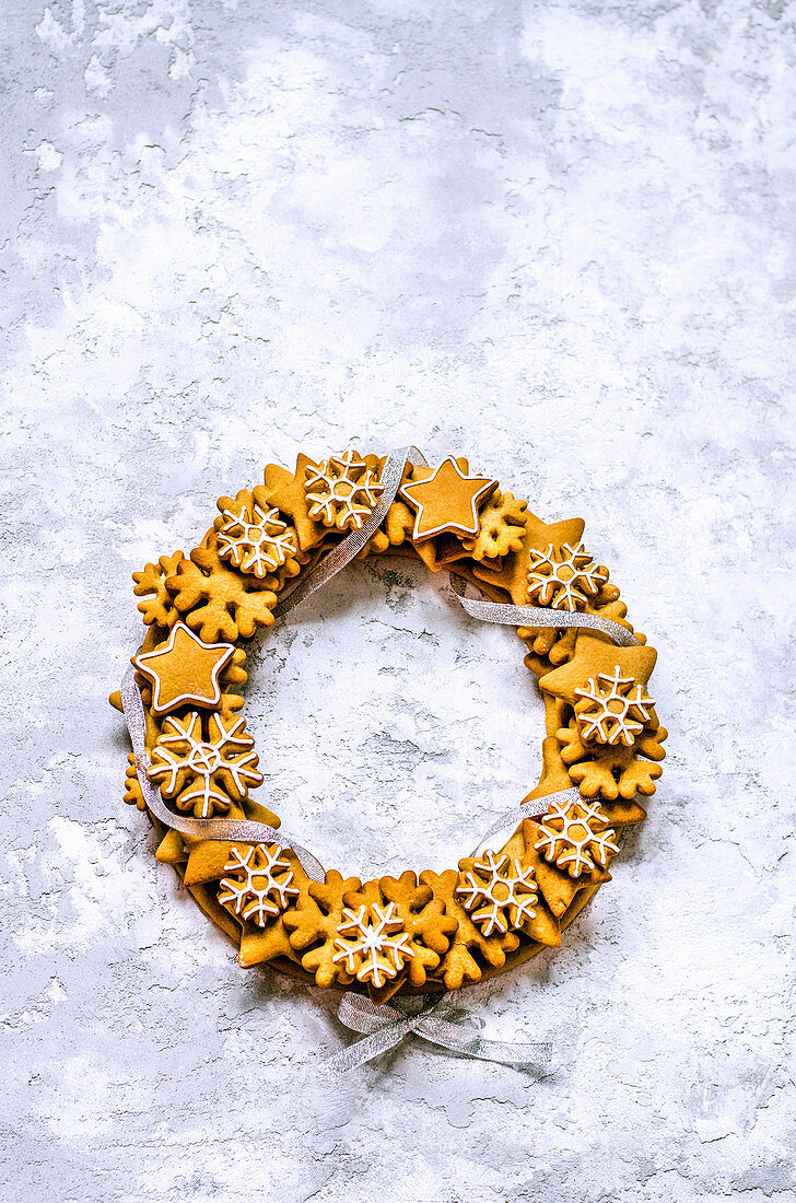 Christmas wreath of gingerbread dough in the shape of stars and snowflakes, tied with a silver ribbon