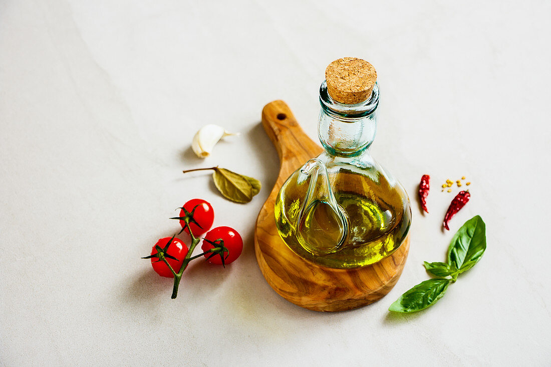 Kännchen mit Olivenöl, Tomaten und Kräuter