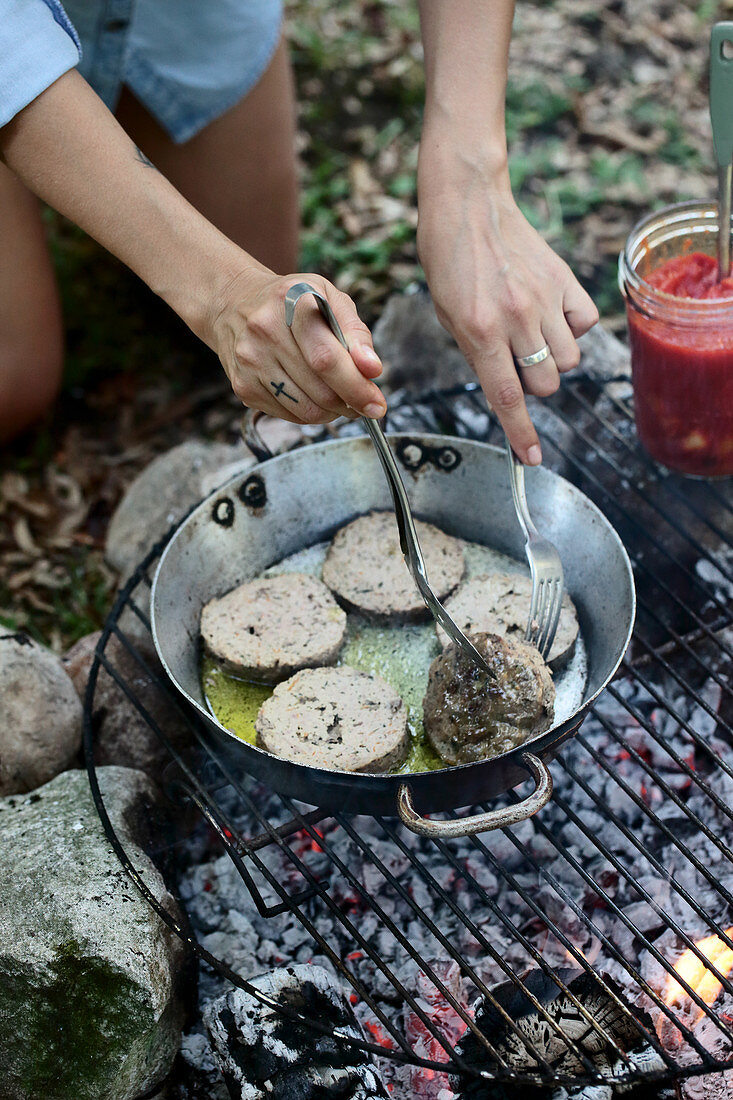 Hackbratenscheiben in der Pfanne auf dem Grillfeuer braten