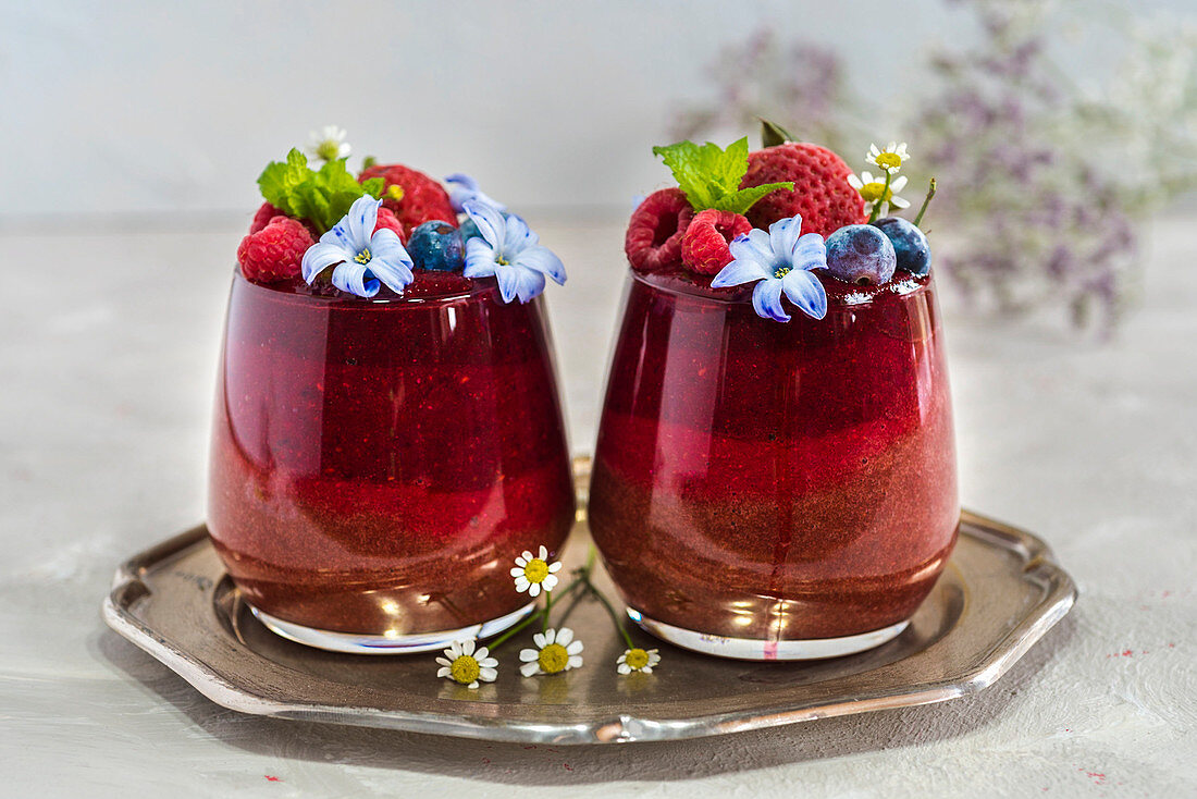 Layered smoothies with berries and flowers
