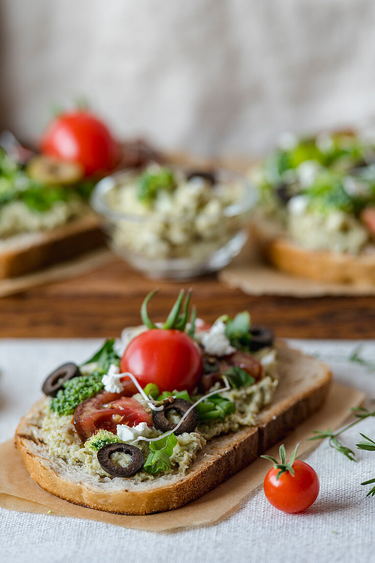 Brokkolipaste mit Feta, Oliven und Tomaten auf Brot