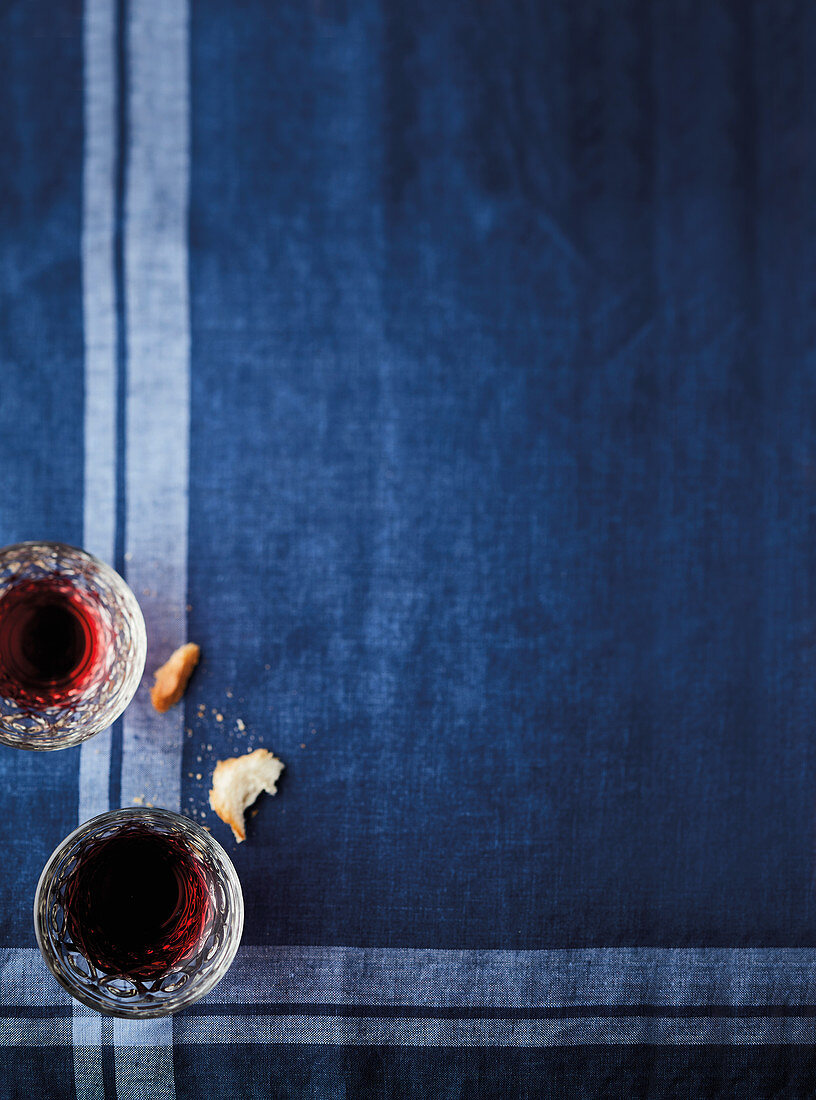 Red wine glasses on a blue tablecloth