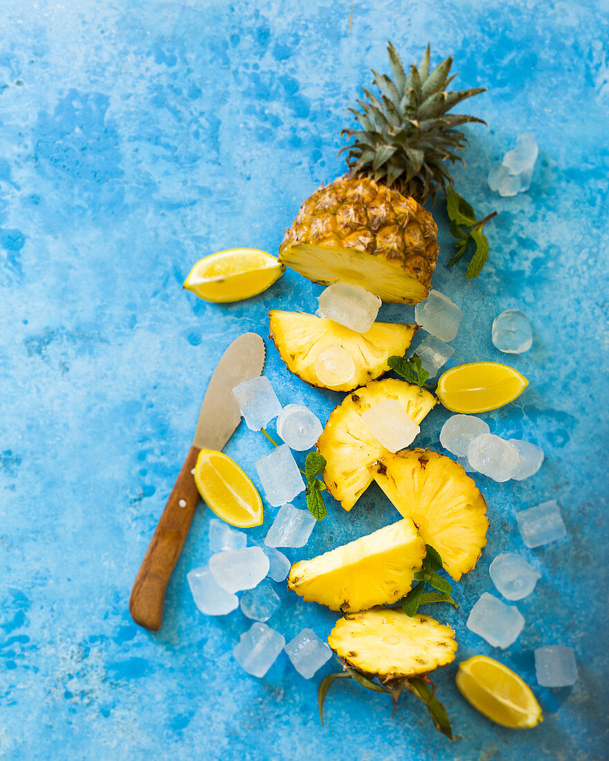 A pineapple, lemon wedges, and ice cubes