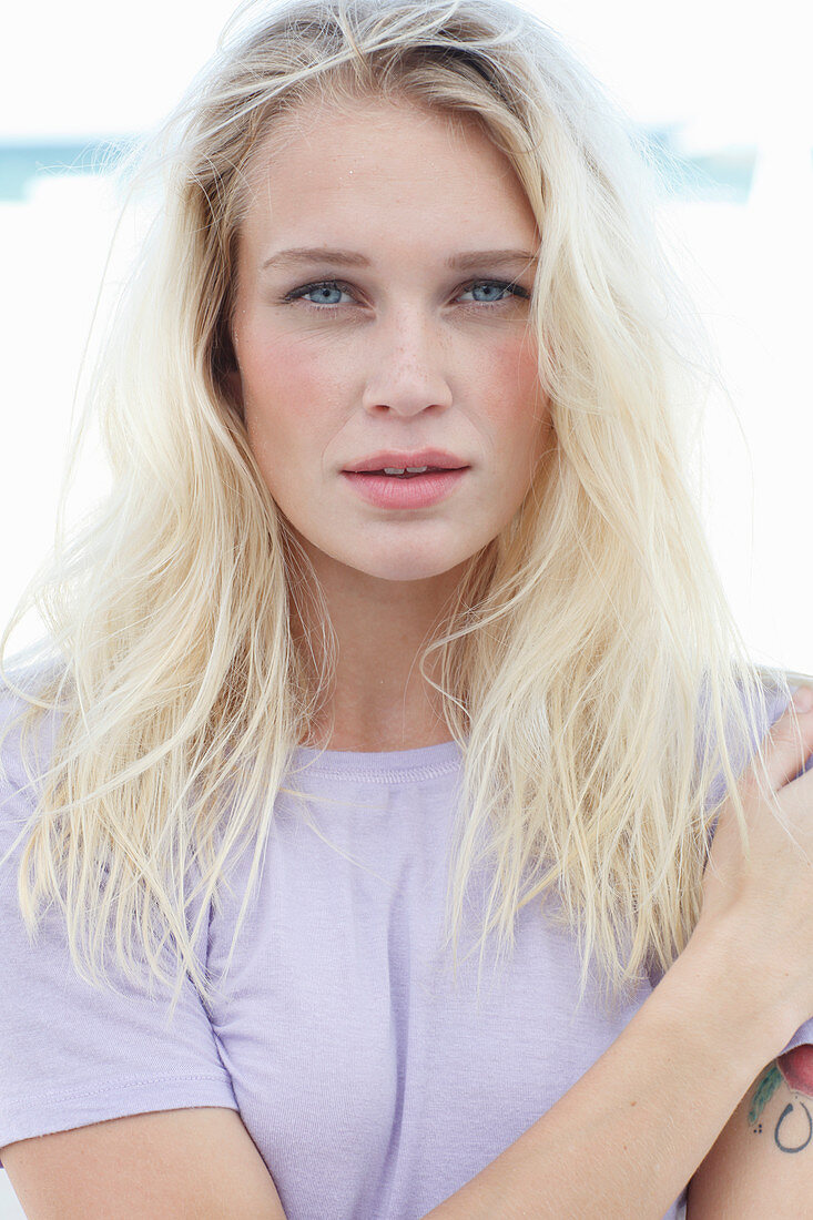 A young blonde woman wearing a purple t-shirt