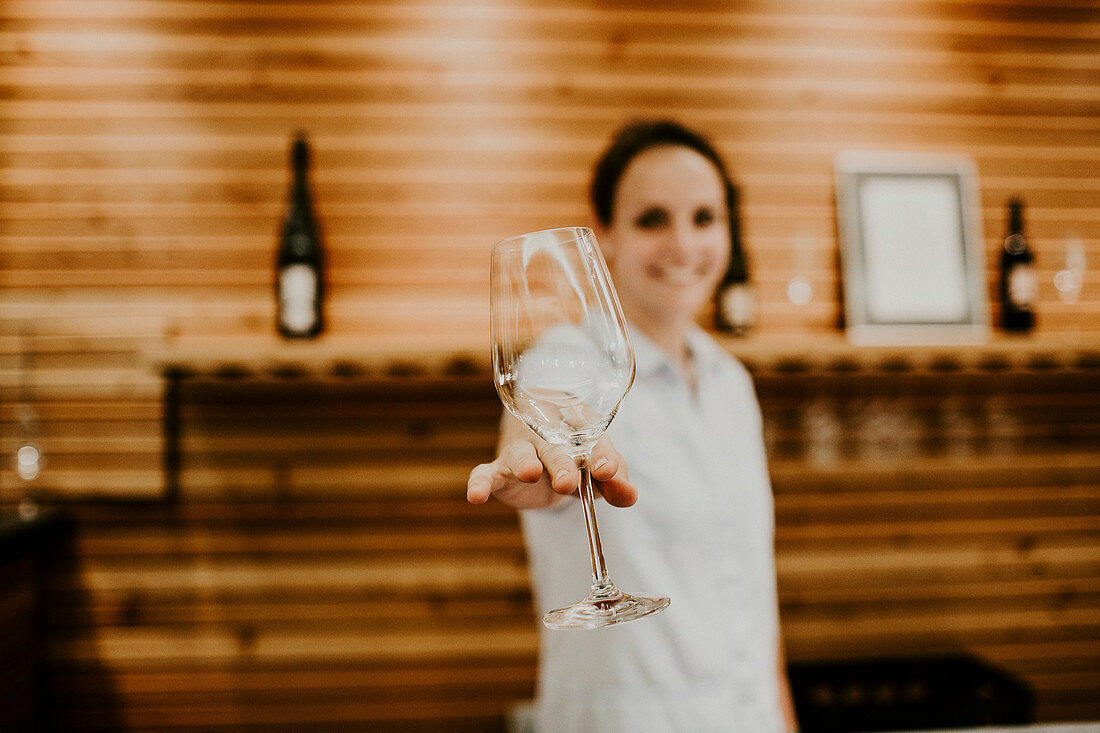 A woman holding an empty wine glass