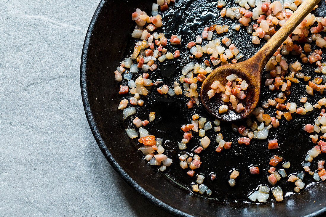 Bacon and onion being fried