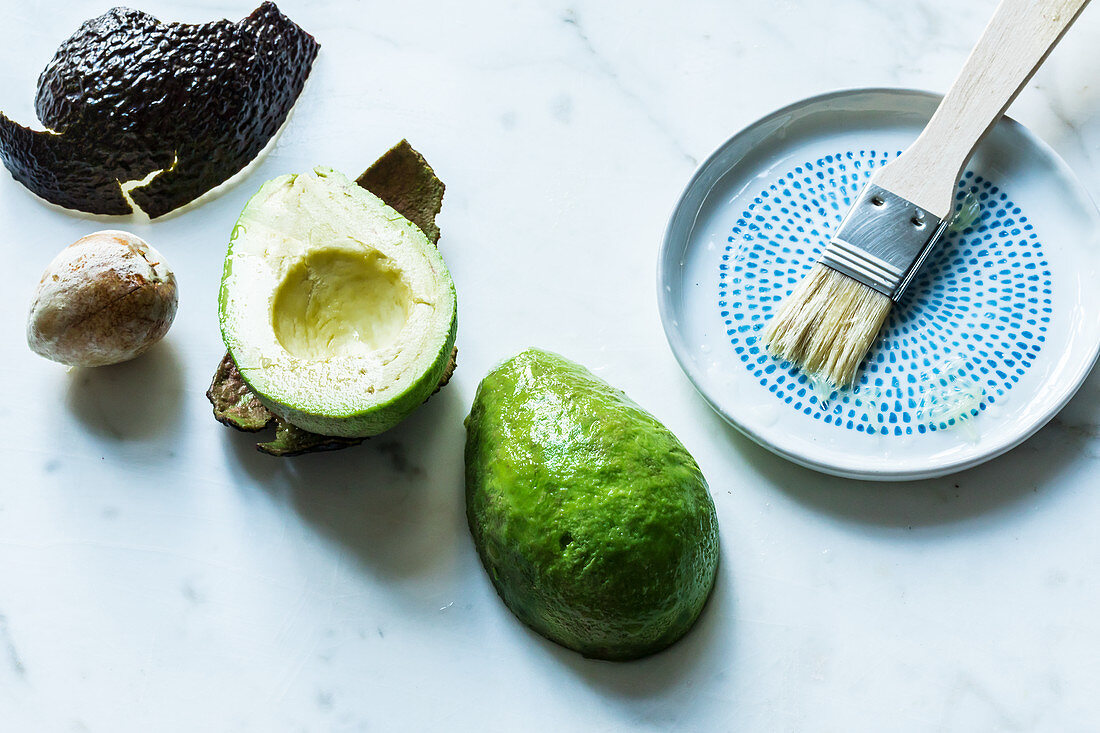 Avocados being prepared and brushed with lemon juice