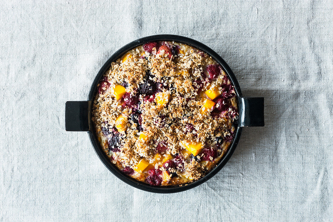 Porridge gratin with mango, berries and coconut