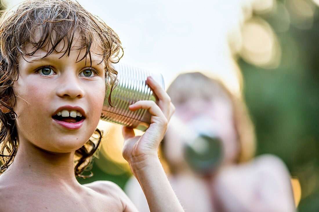 Boys playing with tin can phone