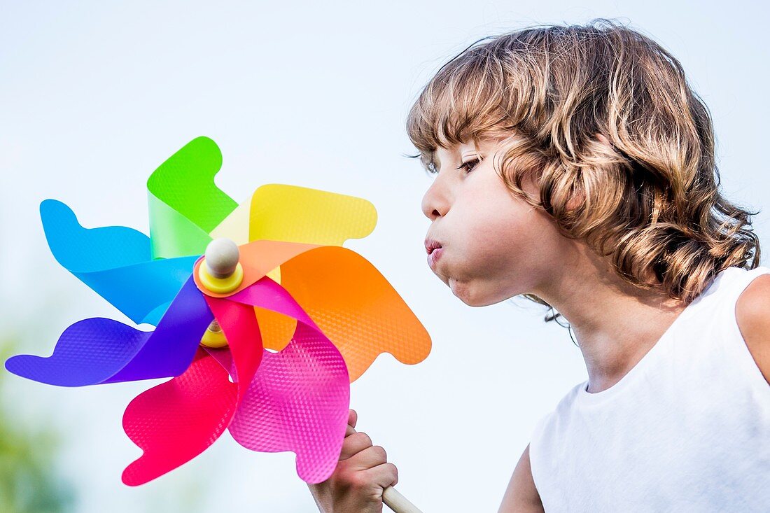 Boy blowing paper windmill